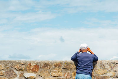 Rear view of woman standing against the wall