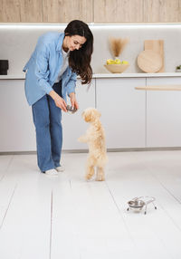 Portrait of young woman with dog on floor