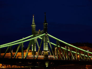 Illuminated bridge against sky at night