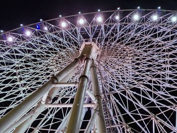 Low angle view of illuminated ferris wheel against sky at night