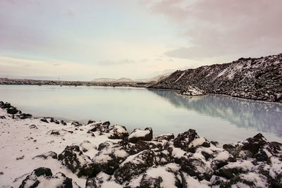 Scenic view of lake and snowcapped mountains against sky