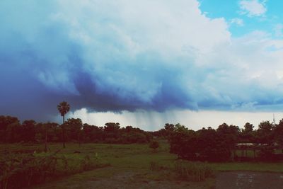 Scenic view of field against cloudy sky