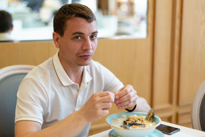 Portrait of young man sitting on table