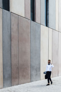 Full length of man standing against building