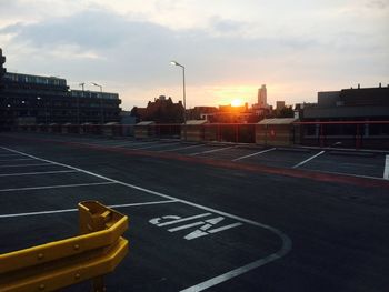 Empty road against sky during sunset