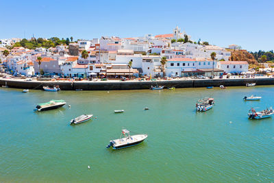 High angle view of townscape by sea against clear sky