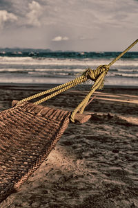 Close-up of rope on beach against sky