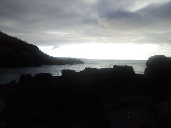 Scenic view of sea and mountains against sky