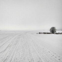 Scenic view of snow covered field against sky