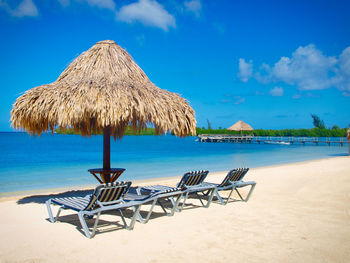 Palapa and beach bed agaist blue sky