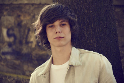 Portrait of man against tree trunk