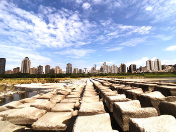 View of city buildings against cloudy sky