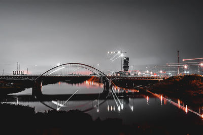 View of bridge over river at night