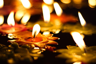 Close-up of lit candles burning at night