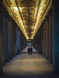 Rear view of man walking in illuminated building