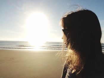 Close-up of woman standing at beach against sky