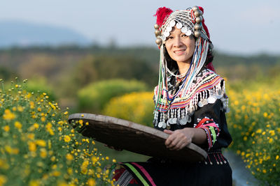 Full length of woman with arms raised on field