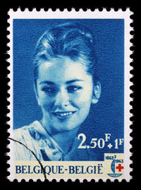 Close-up portrait of a serious young woman over black background