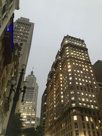 Low angle view of illuminated buildings against sky at dusk