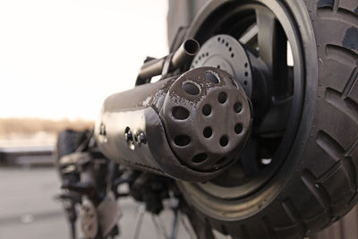 The rear wheel and exhaust pipe on a broken moped