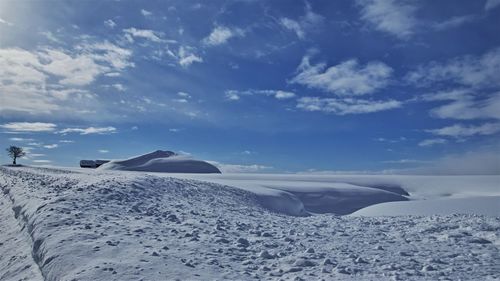 Scenic view of snowcapped landscape against blue sky