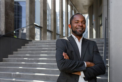 Portrait of young man standing against building