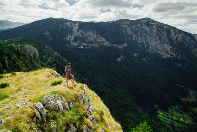 Woman on green mountains against sky