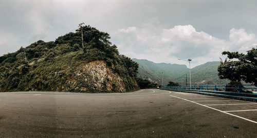 Road by trees against sky