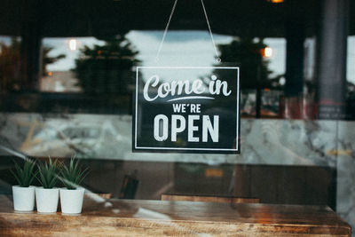 Close-up of information sign on glass window at restaurant