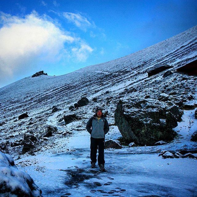 snow, winter, cold temperature, season, mountain, lifestyles, leisure activity, full length, weather, sky, rear view, standing, warm clothing, tranquil scene, beauty in nature, nature, scenics, snowcapped mountain