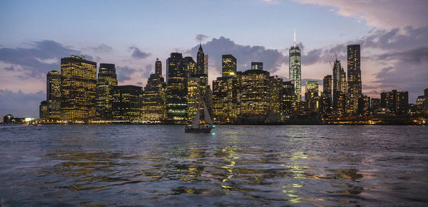 Illuminated buildings against cloudy sky