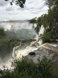 Scenic view of waterfall against sky