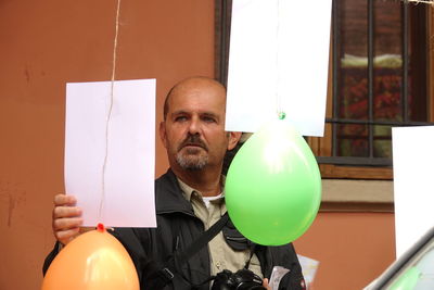 Portrait of man holding balloons