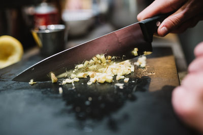 Closeup anonymous person chopping fresh ingredient with sharp knife during cooking course in restaurant kitchen in navarre, spain person