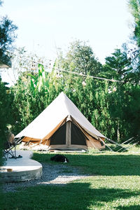 Tent on field by trees against sky