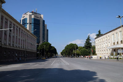 Road amidst buildings in city against sky