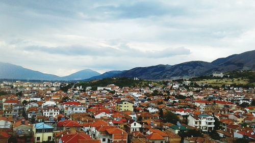 Town by mountains against sky