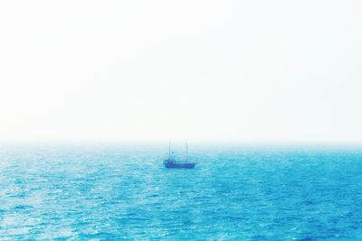 Sailboat sailing on sea against clear sky