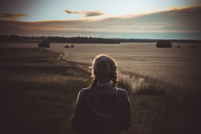 Rear view of woman looking at field