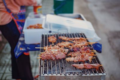 Person preparing food on barbecue grill