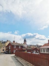 Houses in town against cloudy sky