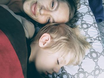 High angle view of mother with son lying on bed at home