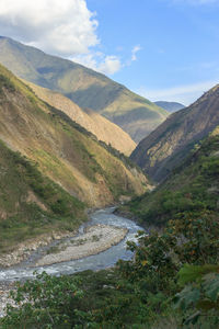 Scenic view of river amidst mountains against sky