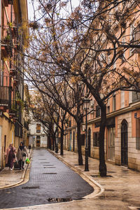 People walking on sidewalk by building in city