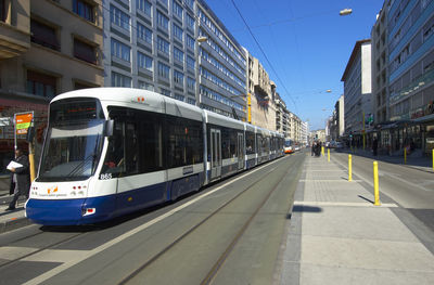Tram moving on street amidst buildings