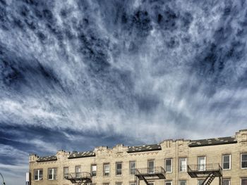 Low angle view of building against cloudy sky