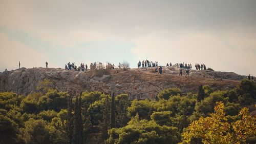 Group of people on mountain  against sky
