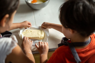 A close view of children hands openning a pack of butter