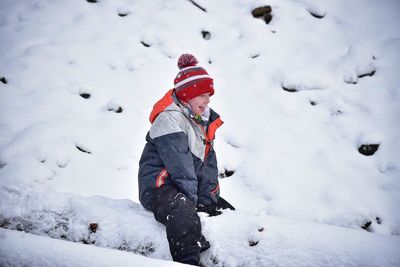 Boy playing on snow covered landscape