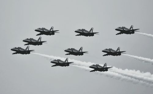 Low angle view of airshow against clear sky